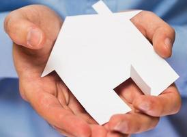 Man holding paper house in his hands photo