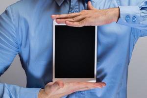 Man in blue shirt holding white tablet pc photo