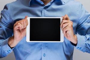 Man in blue shirt holding white tablet pc photo