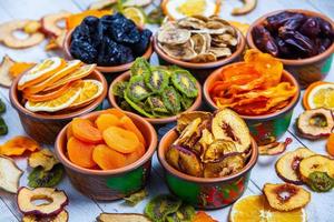 Organic Healthy Assorted Dried Fruit Mix close up. Dried fruit snacks. dried apples, mango, feijoa, dried apricots, prunes top view photo