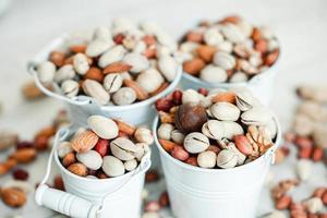 Assorted nuts for a background Almond, walnut,cashew, pistachios, hazelnuts, peanuts, Macadamia Collection of different varieties of nuts. Composition with dried fruits Healthy food. Organic. photo