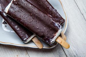 Melting Ice Cream Chocolate Bar Close-up. Ice cream covered with chocolate on wooden background photo