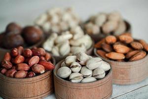 Assorted nuts for a background Almond, walnut,cashew, pistachios, hazelnuts, peanuts, Macadamia Collection of different varieties of nuts. Composition with dried fruits Healthy food. Organic. photo