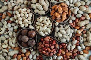 Assorted nuts for a background Almond, walnut,cashew, pistachios, hazelnuts, peanuts, Macadamia Collection of different varieties of nuts. Composition with dried fruits Healthy food. Organic. photo