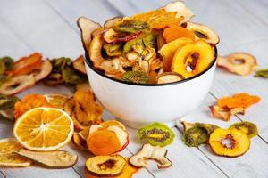 Organic Healthy Assorted Dried Fruit Mix close up. Dried fruit snacks. dried apples, mango, feijoa, dried apricots, prunes top view photo