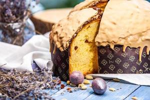 Home Made Panettone. Traditional Italian sweet bread. Panettone with a slice served on a wooden table. photo