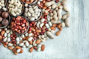 Assorted nuts for a background Almond, walnut,cashew, pistachios, hazelnuts, peanuts, Macadamia Collection of different varieties of nuts. Composition with dried fruits Healthy food. Organic. photo