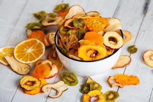 Organic Healthy Assorted Dried Fruit Mix close up. Dried fruit snacks. dried apples, mango, feijoa, dried apricots, prunes top view photo