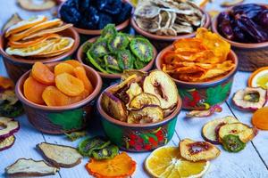 Organic Healthy Assorted Dried Fruit Mix close up. Dried fruit snacks. dried apples, mango, feijoa, dried apricots, prunes top view photo