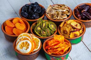 Organic Healthy Assorted Dried Fruit Mix close up. Dried fruit snacks. dried apples, mango, feijoa, dried apricots, prunes top view photo