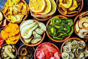 Organic Healthy Assorted Dried Fruit Mix close up. Dried fruit snacks. dried apples, mango, feijoa, dried apricots, prunes top view photo