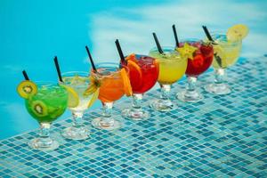 Various alcoholic cocktails on white background. Colorful cocktails close up. Fruit juice cocktail drink. assorted cocktail drinks. Glasses of fruit drinks with ice cubes on table in cafe photo