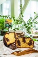 panettone casero. pan dulce tradicional italiano. panettone con una rodaja servido en una mesa de madera.