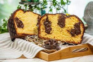 Home Made Panettone. Traditional Italian sweet bread. Panettone with a slice served on a wooden table. photo