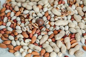 Assorted nuts for a background Almond, walnut,cashew, pistachios, hazelnuts, peanuts, Macadamia Collection of different varieties of nuts. Composition with dried fruits Healthy food. Organic. photo
