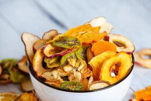 Organic Healthy Assorted Dried Fruit Mix close up. Dried fruit snacks. dried apples, mango, feijoa, dried apricots, prunes top view photo