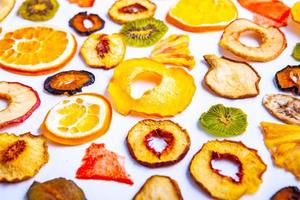 Organic Healthy Assorted Dried Fruit Mix close up. Dried fruit snacks. dried apples, mango, feijoa, dried apricots, prunes top view photo