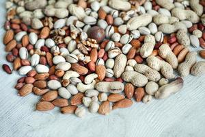 Assorted nuts for a background Almond, walnut,cashew, pistachios, hazelnuts, peanuts, Macadamia Collection of different varieties of nuts. Composition with dried fruits Healthy food. Organic. photo