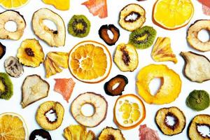 Organic Healthy Assorted Dried Fruit Mix close up. Dried fruit snacks. dried apples, mango, feijoa, dried apricots, prunes top view photo