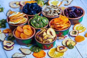 Organic Healthy Assorted Dried Fruit Mix close up. Dried fruit snacks. dried apples, mango, feijoa, dried apricots, prunes top view photo