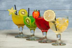 Various alcoholic cocktails on white background. Colorful cocktails close up. Fruit juice cocktail drink. assorted cocktail drinks. Glasses of fruit drinks with ice cubes on table in cafe photo