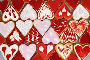 galletas del día de san valentín. galletas en forma de corazón para el día de san valentín. galletas en forma de corazón rojo y rosa. patrón romántico sin costuras con corazones de galletas. foto