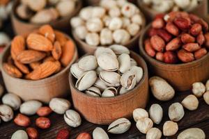 Assorted nuts for a background Almond, walnut,cashew, pistachios, hazelnuts, peanuts, Macadamia Collection of different varieties of nuts. Composition with dried fruits Healthy food. Organic. photo