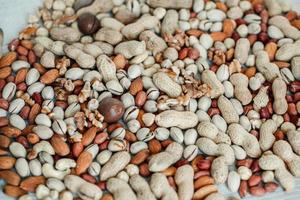 Assorted nuts for a background Almond, walnut,cashew, pistachios, hazelnuts, peanuts, Macadamia Collection of different varieties of nuts. Composition with dried fruits Healthy food. Organic. photo