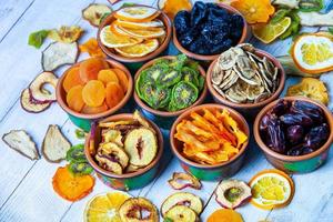 Organic Healthy Assorted Dried Fruit Mix close up. Dried fruit snacks. dried apples, mango, feijoa, dried apricots, prunes top view photo