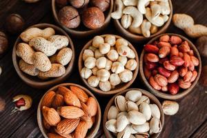 Assorted nuts for a background Almond, walnut,cashew, pistachios, hazelnuts, peanuts, Macadamia Collection of different varieties of nuts. Composition with dried fruits Healthy food. Organic. photo