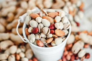 Assorted nuts for a background Almond, walnut,cashew, pistachios, hazelnuts, peanuts, Macadamia Collection of different varieties of nuts. Composition with dried fruits Healthy food. Organic. photo