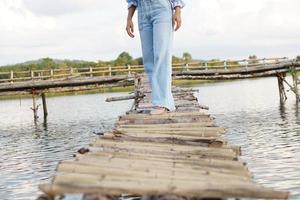 una turista asiática camina por un puente de bambú para llegar al mirador foto