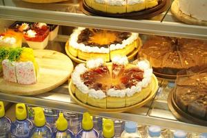 pastel en vitrina cortado en pedazos vendidos en una cafetería foto