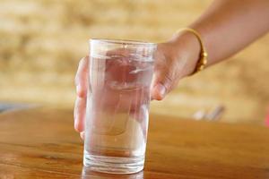 woman holding a glass of water to drink photo