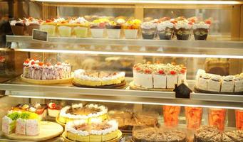 pastel en vitrina cortado en pedazos vendidos en una cafetería foto