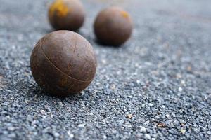 Petanque boules on a field with small stones photo