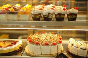 pastel en vitrina cortado en pedazos vendidos en una cafetería foto