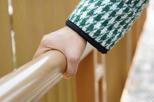 human hand touch Wooden railings at tourist attractions are vulnerable to Covid-19 photo