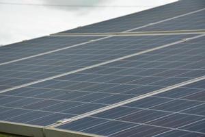 selective focus.Solar panels on the roof of a tropical city house early in the morning photo