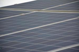 selective focus.Solar panels on the roof of a tropical city house early in the morning photo