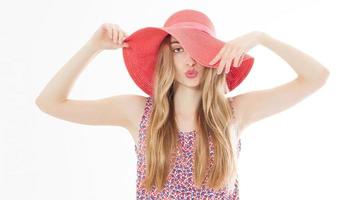 hermosa chica con un sombrero rojo sonriendo al fondo de verano aislado. foto