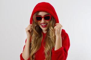 Happy stylish young woman in red hoodie, sunglasses isolated on white background. Close-up girl smiling face. Fashion and beauty concept. photo