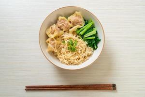 dried egg noodles with pork wonton or pork dumplings without soup photo
