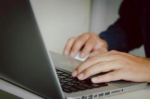 Man hand using a computer to type on a keyboard to find information on the Internet on social networks. photo