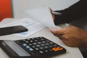 hombre de negocios con calculadora en un escritorio. conceptos de finanzas comerciales, impuestos e inversiones. foto