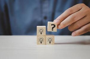 Hand put wooden cubes with question mark symbol on table and copy space.Business concepts. photo