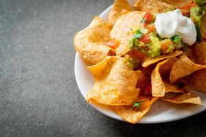 nachos chips de tortilla con jalapeño, guacamole, salsa de tomates y dip foto