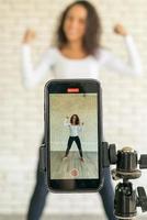 Latin woman created her dancing video by smartphone camera. To share video to social media application. photo