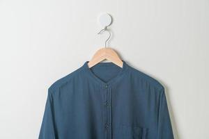 hanging shirt with wood hanger on wall photo