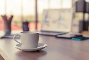 taza de café con leche en la mesa de trabajo foto